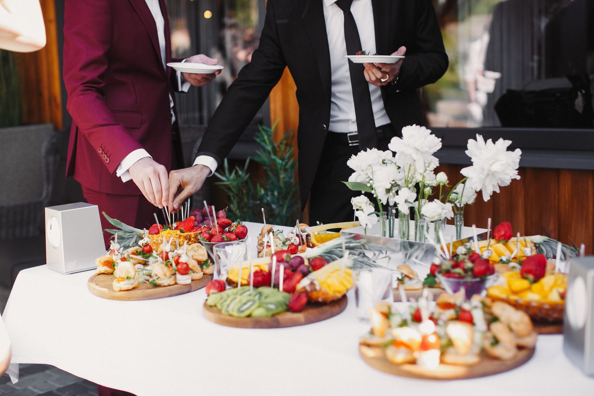Close up of people serving themselves with fruits in buffet of restaurant